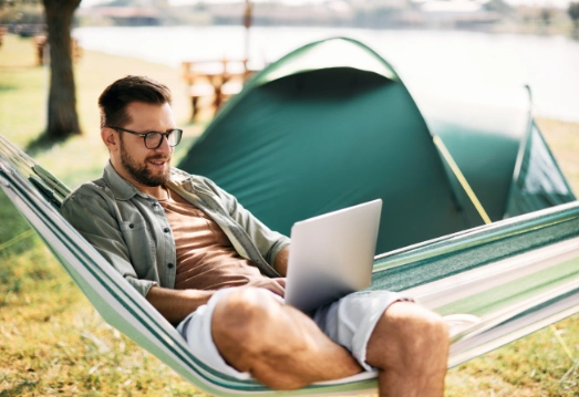 man enjoying satellite connection while on a camping trip